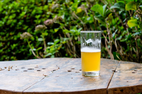 Half Full Beer Cup On Top Of Wooden Table