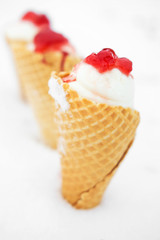 ice cream in waffle cone with red jelly in snow