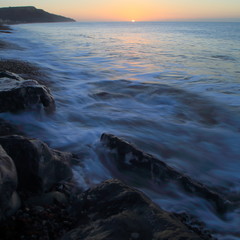 Blurred sea waves at sunrise on the Jurassic Coast near town of Seaton in Devon