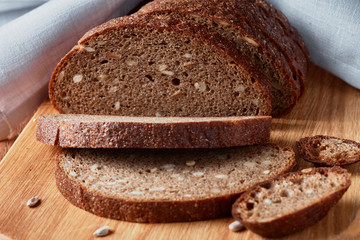 Fototapeta na wymiar Slice of rye bread with seeds on a wooden background