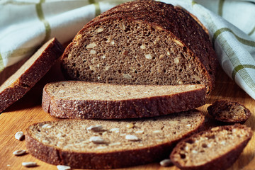 Slice of rye bread with seeds on a wooden background