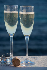 Two glasses with champagne or cava served outside on terrace, luxury resort with sea view, romantic vacation