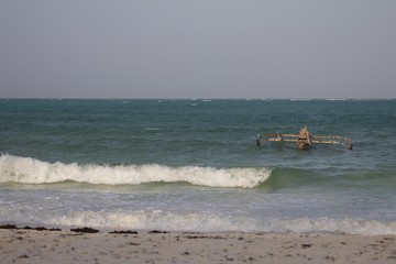 Wooden fishing boat alone in the ocean at a beach in Zanzibar, Tanzania (africa)