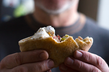 Authentic man holding a bitten off fajita side view