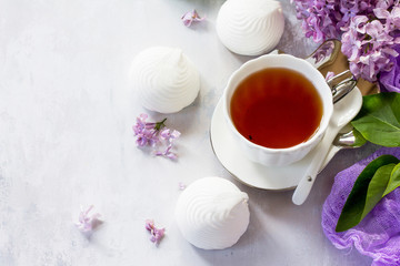 Relaxation time concept. Homemade zephyr with cup of tea on a cozy kitchen table. Copy space, top view flat lay background.