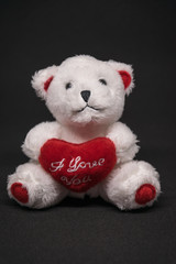 Weißer Teddybär mit roten Ich liebe Dich Herz auf schwarzen Hintergrund