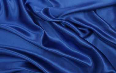 Smooth elegant blue silk or satin luxury cloth texture as abstract background. Luxurious Christmas background or New Year background design