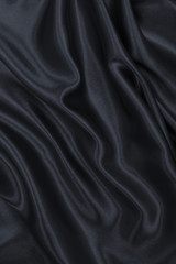 Smooth elegant dark grey silk or satin texture as abstract background. Luxurious background design