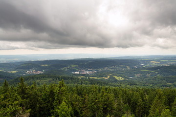 Fototapeta na wymiar Beautiful summer forest view from Pajndl lookout tower cloudy sky copy space, Tisovsky Mount in Krusne Hory, Bohemia, Czech Republic