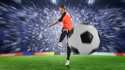 female football player in orange uniform kicking the ball