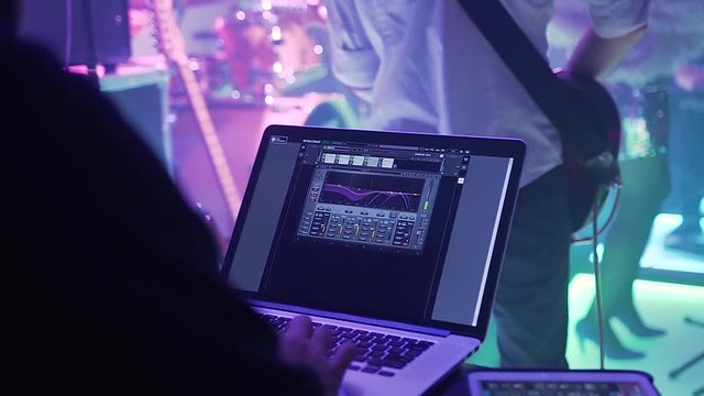 Laptop with program, DJ mixer, DJ adjusting music at the party