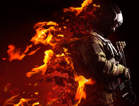 Profile view photo of a swat soldier with fire dissolving effect on black background.