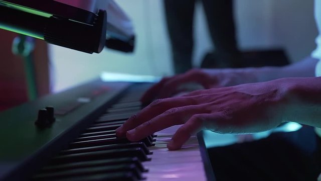 The man plays keyboard at an party disco in the restaurant