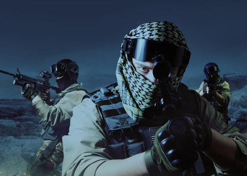 Special operation military soldiers posing on night desert background.