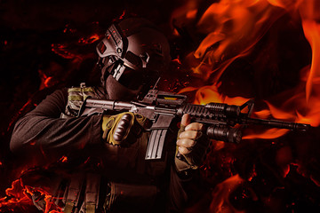 Fototapeta na wymiar Photo of a swat soldier aiming automatic rifle with flame effects.
