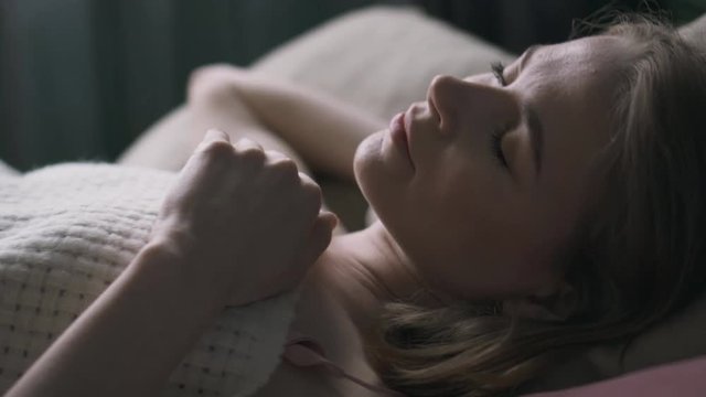Young woman yawning while waking in bed