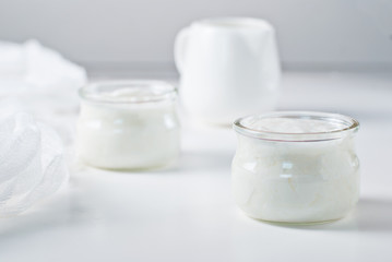 Yogurt in two jars with milk jug