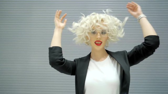 a young and beautiful lady with bright lipstick and curls on blond hair has a bright lipstick on her lips and dark shadows, a woman dresses stylish glasses