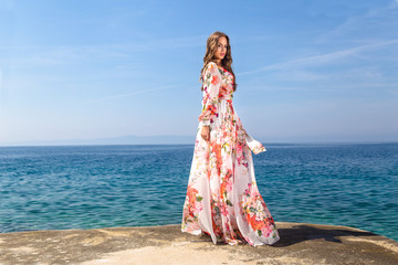 Fototapeta na wymiar Woman in a summer dress at the sea