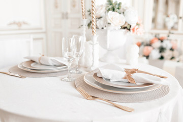 Close-up layout of the festive table. decorated table and chairs for a festive dinner. Luxury decor with daylight. modern photographic studio. Light spring room studio interior.