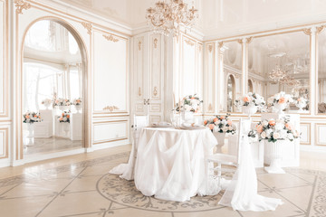 decorated table and chairs for a festive dinner. Luxury decor with daylight. modern photographic studio. Light spring room studio interior.