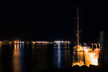 Fototapeta na wymiar Sailing boat moored to a floating pontoon. Night, long exposure.