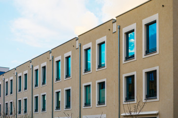 Fototapeta na wymiar some brown apartment townhouses with white framed windows