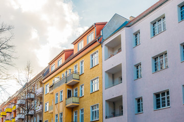 colorful houses in a row with big clouds