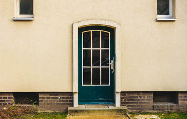 Fototapeta na wymiar green entrance door on yellow facade