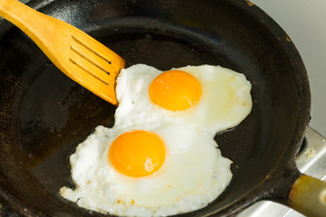 A couple of eggs for Breakfast. Fried eggs in a frying pan.