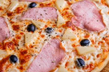 Close up texture of pizza with ham and black olives, macro. Italian food, restaurant menu concept