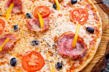 Close up texture of delicious sicilian pizza with bacon, olives and tomatoes, food background