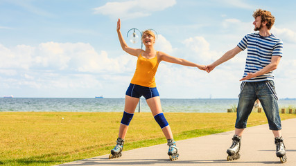 Young couple on roller skates riding outdoors