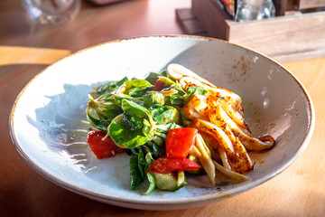 The salad with calamari, tomatoes and corn in a bowl