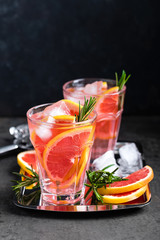 Grapefruit and fresh rosemary gin cocktail with juice, cold summer citrus refreshing drink or beverage with ice