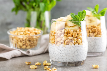 Layered chia pudding parfait with banana, sweet wheat with honey and yogurt, dessert