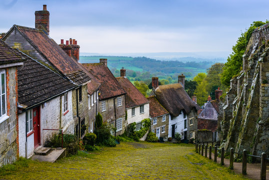 A row of cottages on a steep cobbled street at Gold Hill in Shaftesbury, Dorset, United Kingdom, England. Great Britain