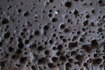 Oil stained and drill hole on old wooden table in garage or factory.