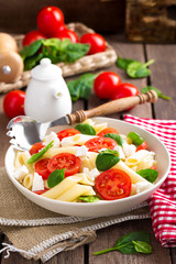Pasta salad with fresh red cherry tomato and feta cheese. Italian cuisine