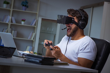 Young man playing games long hours late in the office © Elnur