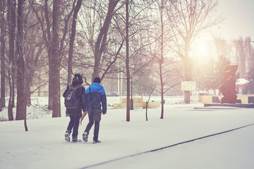 boys walking on snow covered park