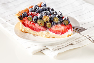 Serving homemade mix berry tart with fresh berries.