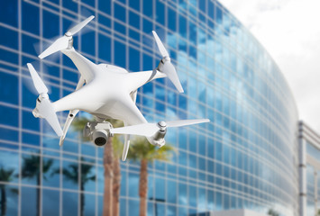 Unmanned Aircraft System (UAS) Quadcopter Drone In The Air Near Corporate Building.