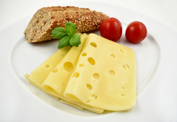 Slice of cheese with garnish stock images. Piece of cheese with tomatoes and basil. Cheese isolated on a white background. Healthy snack images