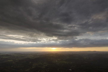 A sunset in clouds by the mountain