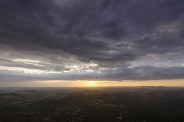 A sunset in clouds by the mountain