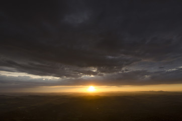 A sunset in clouds by the mountain