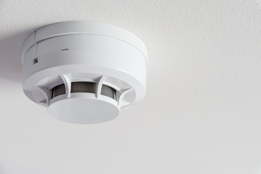 Close up smoke detector on a ceiling.