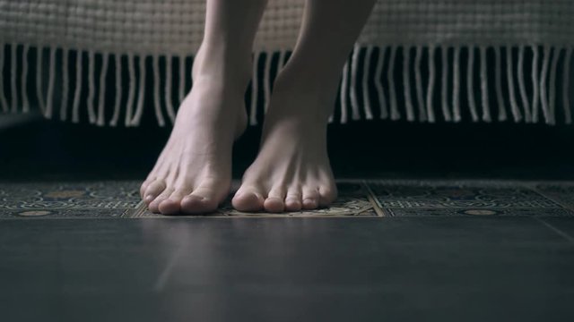 Feet of woman getting out the bed in the morning