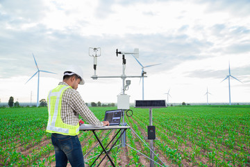 Engineer using tablet computer collect data with meteorological instrument to measure the wind...